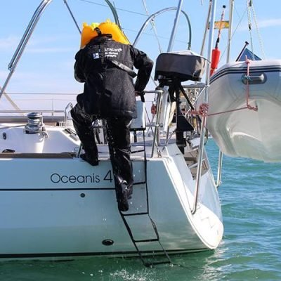 Image of a man over board clibming the steps on to the sailboat using the Emergency ladder