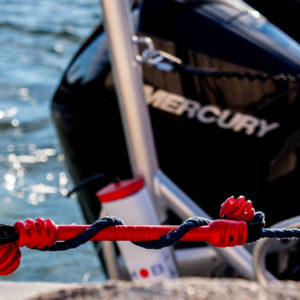 Finnish Mooring & Dock Line Shock Absorber Close-up of a snubber being used by a boat and a red color on a water background