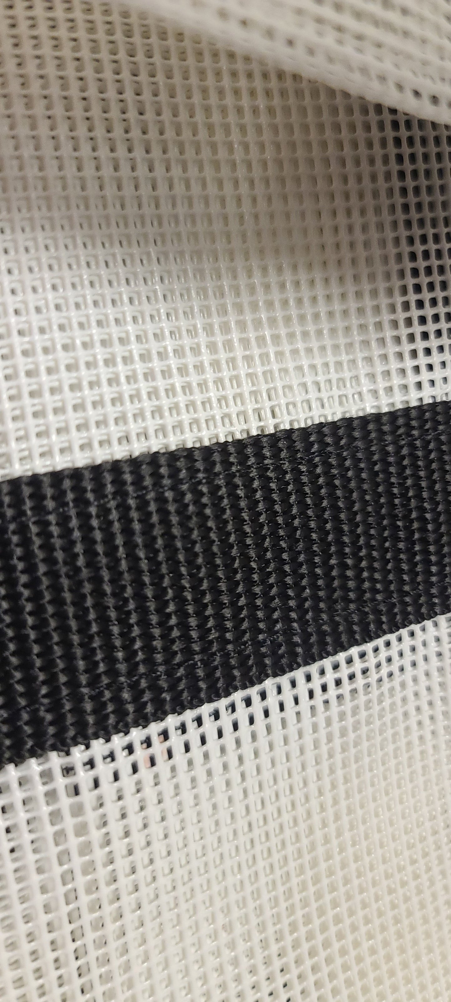 Yacht bunk accessory, close up of  white netting and blck trim