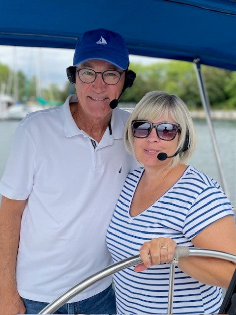 Picture of a sailing couple wearing the 2 Talk Bluetooth Headsets