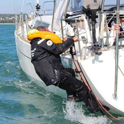 Image of a man over board climbing back onto his boat.