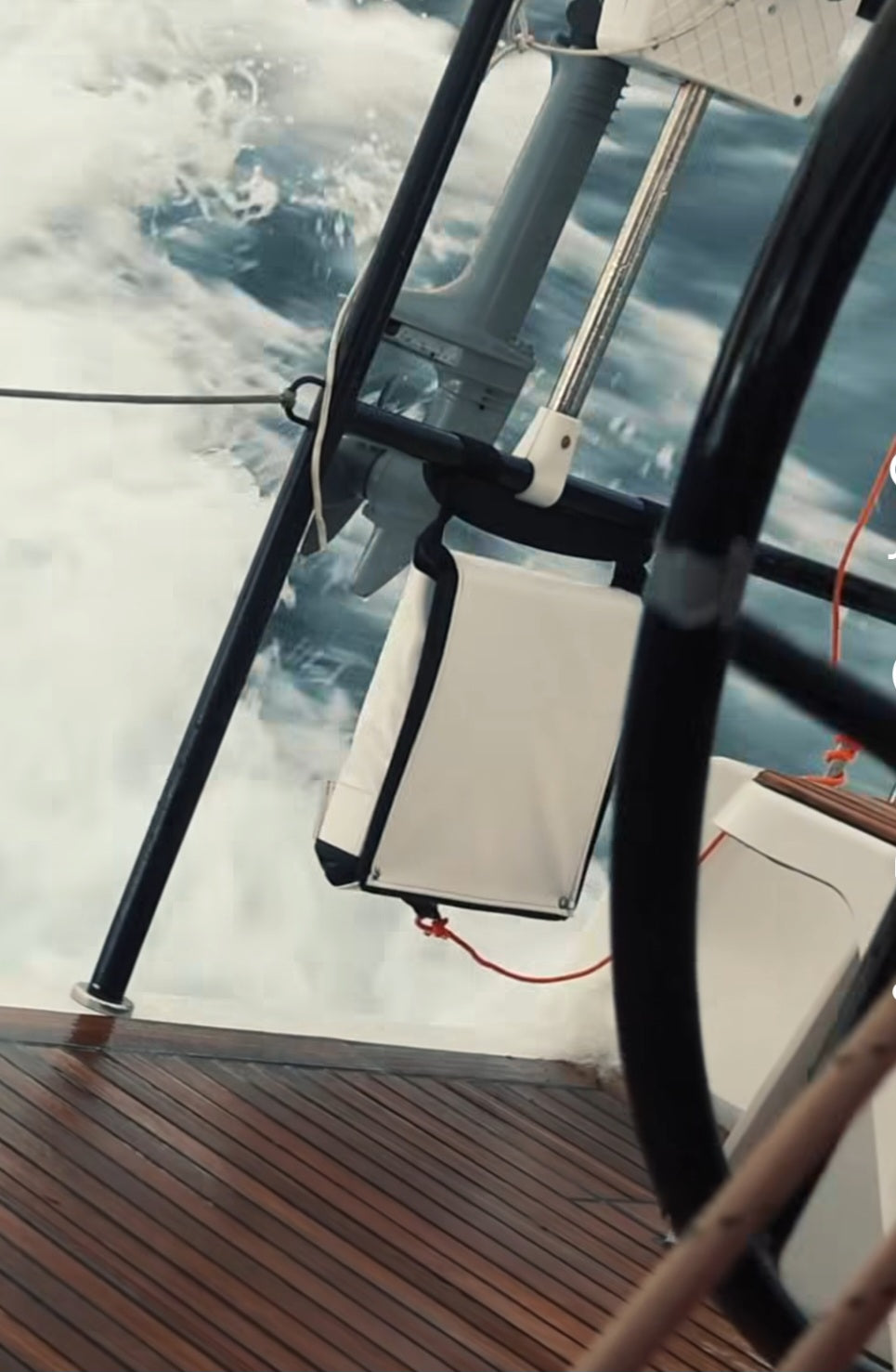 An 11  step emergency ladder on the back of a sailboat that is racing in the ocean.